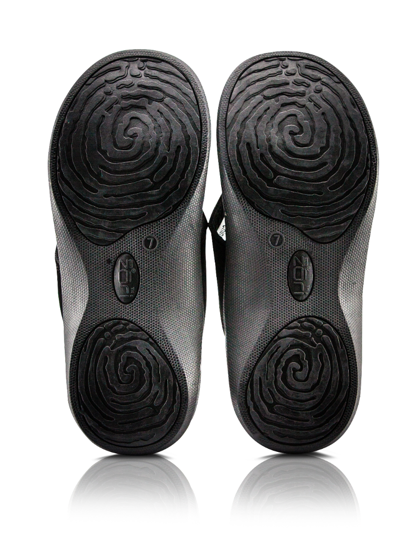 Neat Zori Black Orthotic Thong/Sandal, both flipped to show their underside, featuring grippy pads on the heel and front, displayed side by side.